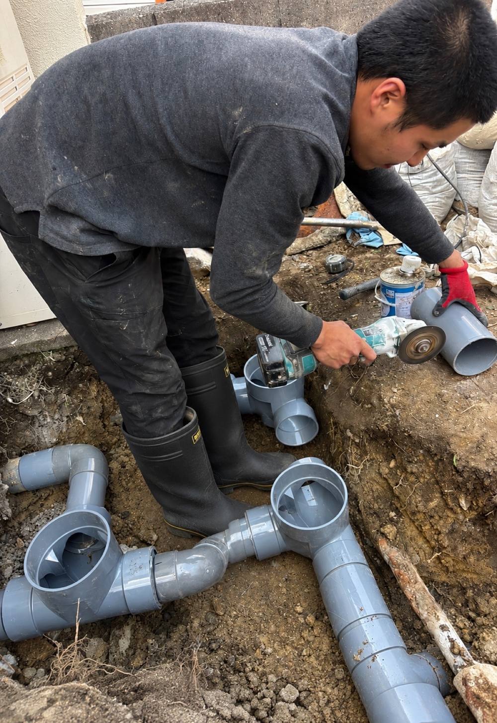 掘削した地面で排水マスと配管を切断・接続する施工現場